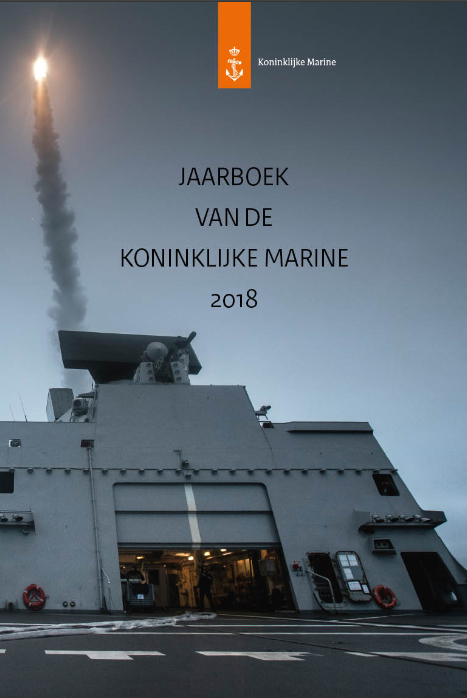 Kleurenfoto met de tekst Jaarboek van de Koninklijke Marine. Op de foto is het dek van een schip te zien, met een stuk geschut.