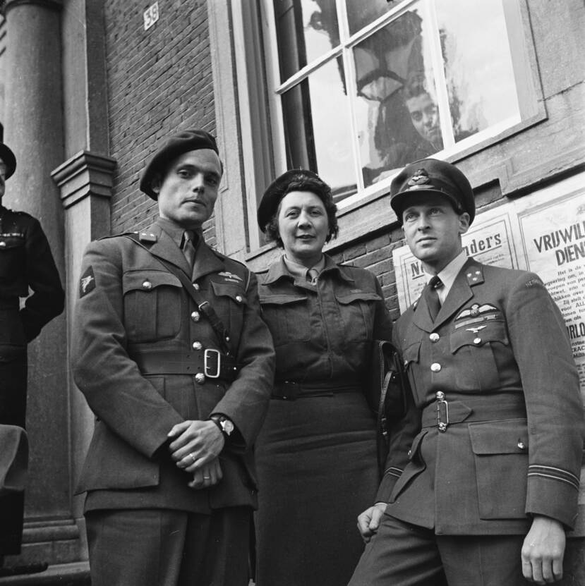 Zwart-witfoto, de 2 mannen in militair uniform en Knapper in het midden ook in uniform. Door het raam achter hen kijkt iemand naar buiten.